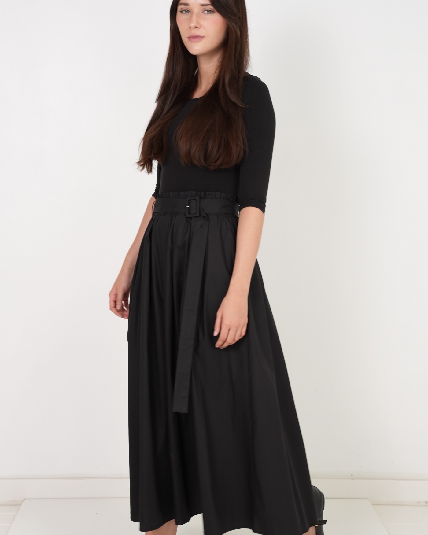 Model walking in a black PEODE maxi skirt