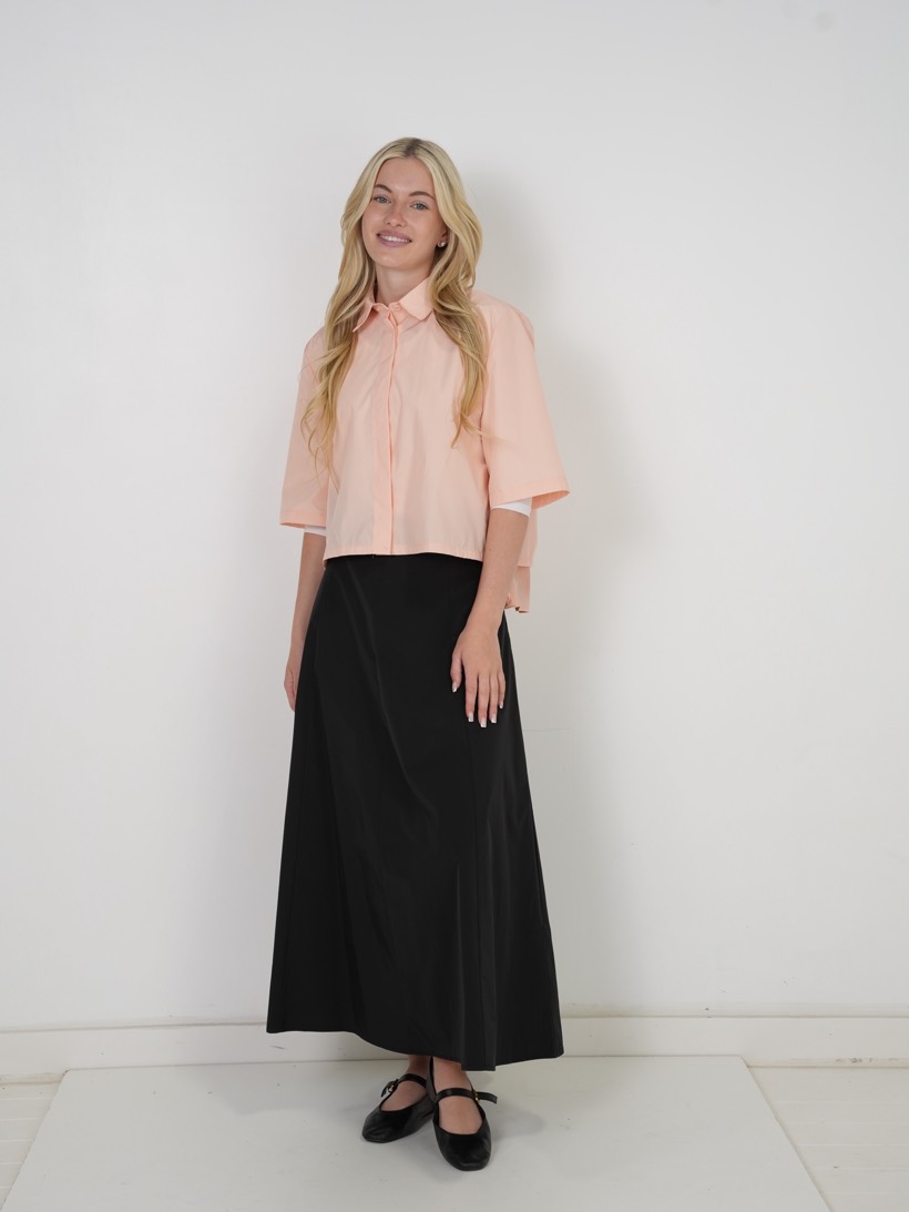 Peach blouse over a black maxi